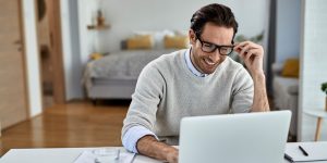 Happy freelance worker using computer while working at home.