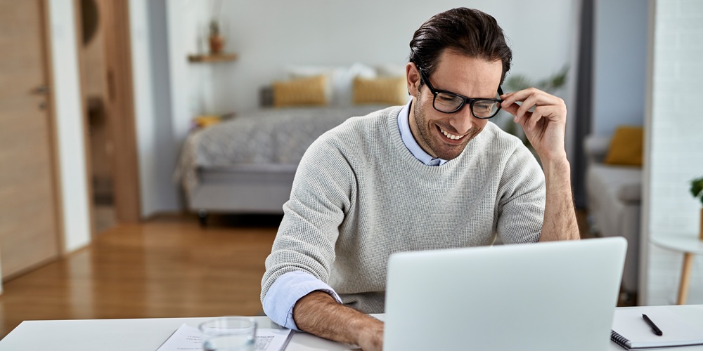 Happy freelance worker using computer while working at home.